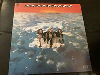 Front cover of Aerosmith LP showing the band members and sky background with orange top border