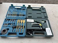 Set of drill bits, spade bits, hole saws in blue case and electric stapler case with glue gun included