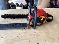 Full side view of Homelite 3514c chainsaw showing 14-inch chain bar and blade cover on a wooden table.