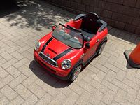 Front angled view showing red body, black racing stripes, one headlight cover missing, and seat.