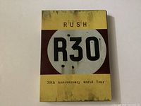 Front cover of Rush R30 30th Anniversary World Tour DVD case showing aged yellow design with R30 logo