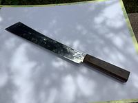Photo of the full length vintage Foster Bros cutter knife showing the rectangular shiny blade and wooden handle with three rivets.