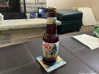 Full view of the Labatt 50 D-Day commemorative beer bottle on a coaster, showing label and bottle condition.