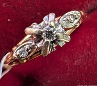 Frontal close-up showing floral head and central round diamond