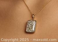 Pendant front view on chain against neutral background