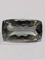 Top-down view of rectangular green amethyst gemstone showing faceted cut and transparency.
