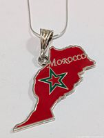 Front view of sterling silver necklace with red enamel Morocco pendant showing the star emblem and Morocco name.