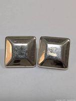 Two square dome-shaped silver earrings shown front-facing with a polished finish.