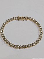 Photo of bracelet laid flat showing entire piece with cubic zirconia stones set in linked segments.