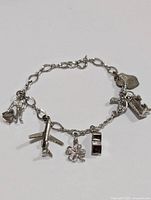 Silver charm bracelet laid flat showing charms and chain links