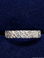 Top view of silver ring showing detailed Celtic knot pattern on band.