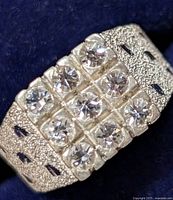 Close-up front view of silver ring showing textured band and 9 clear stones arranged in 3x3 grid.