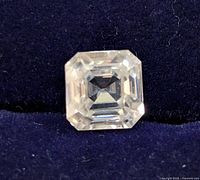 Close-up image of the 2.25ct Ascher cut moissanite loose gemstone on navy blue background showing the step-cut facets.
