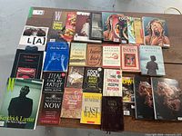 Overhead photo showing a spread of soft and hardcover books and magazines arranged on a surface, titles and authors visible, including novels, poetry, and magazines.