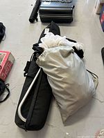 Initial overview of black frame bag, aluminum frame tube, and gray scrim storage bag