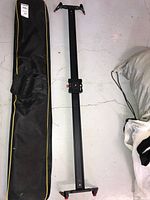 Full view of the Neewer camera slider alongside its carrying case on a floor surface