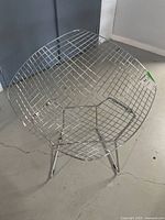 Top view showing the diamond pattern metal wire seat of the chair and metal frame.