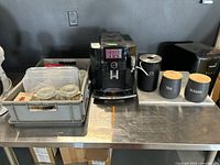 Full lot overview showing machine, bin, canisters on stainless table