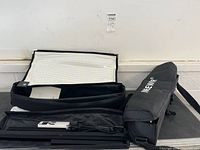 Two carrying cases with one open revealing flexible LED panel and stand components