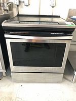 Front view of stainless steel Whirlpool electric range showing oven door with window and control panel above
