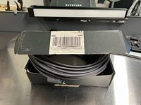 Partially unboxed coiled black rubber cable with Starlink label visible on box.