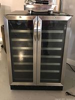 Front view of wine cooler showing dual glass doors with stainless steel frame and handles