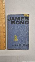 Front cover of the 1965 Dr No James Bond book showing title, author, and Pan Books branding with a spider web design.