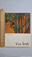 Front cover of the first Van Gogh art book showing a scene with trees and two figures walking on a path. A ruler is placed next to the book for scale.