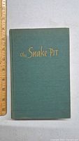 Front cover of the 1946 first edition green cloth book 'The Snake Pit' by Mary Jane Ward, gold embossed title visible.