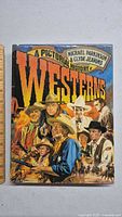 Front cover of the colorful illustrated hardcover book showing various Western characters and the title.