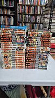 Front view of stacked Naruto manga volumes 1 through 72 with the special Naruto Shonen Jump issues on top, showing spines with titles and volume numbers.