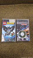 Front view of LEGO Batman The Videogame and Need for Speed Underground Rivals PSP games showing covers and UMD disc