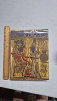 Photo showing the front cover of the Tutankhamun book with a ruler placed nearby for scale.