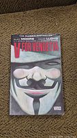 Front cover of 'V for Vendetta' paperback graphic novel showing the Guy Fawkes mask and title.