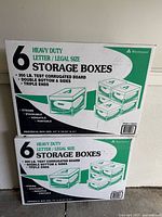 Two sealed boxes containing 6 heavy duty letter/legal size storage boxes each by Weyerhaeuser with product details on the packaging.