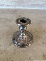 Front view of the antique Prelude International sterling silver weighted candle holder showing the decorative floral engraving on the base and candle cup.