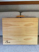 Closed wooden case with natural wood finish, shows 'Art Studio Classic' logo in bottom corner and wooden top handle.