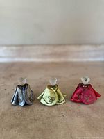 Photo of three Prince Douka figural perfume bottles arranged in a row showing front caps and frosted head stoppers.