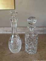 Both decanters side by side on stone surface