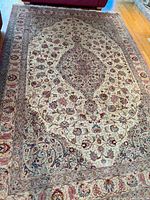 Full view of rug on hardwood floor showing central medallion and floral border