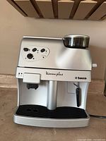 Front view of the silver Saeco Vienna Plus showing drip tray, control panel and steam wand