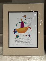 Framed and matted vintage print by Brian Andreas, signed and titled 'Center on Wheels'. Shows the full artwork and matting with plastic wrap reflections.