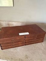 Brown felt-like organizer box with eight pull-out drawers for plates