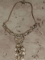 Full view of vintage rhinestone necklace laid flat showing the chain and pendant design.