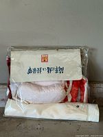Front view of the kimono, obi belt, and collar in original packaging showing labels and folded items