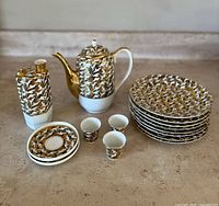 Overall view of tea pot, sake decanter, cups, saucers and plates on countertop