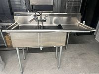Front view of entire stainless steel double sink unit on legs