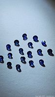 Photo showing multiple natural royal blue diamond cut sapphires, arranged in rows, displaying size and color consistency.