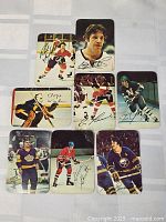Seven 1977-78 OPC All Star Insert hockey cards laid out on a flat surface showing front images of players in various action and posed shots with facsimile autographs.