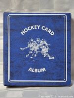 Front view of blue binder labeled "Hockey Card Album" with an image of hockey players.